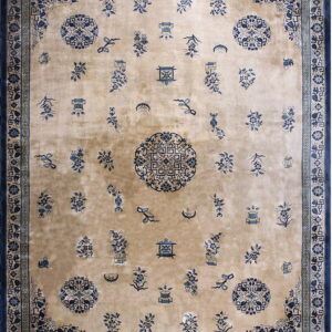 Tan field rug with scattered blue floral motifs, vases, and medallions, framed by wide geometric borders.