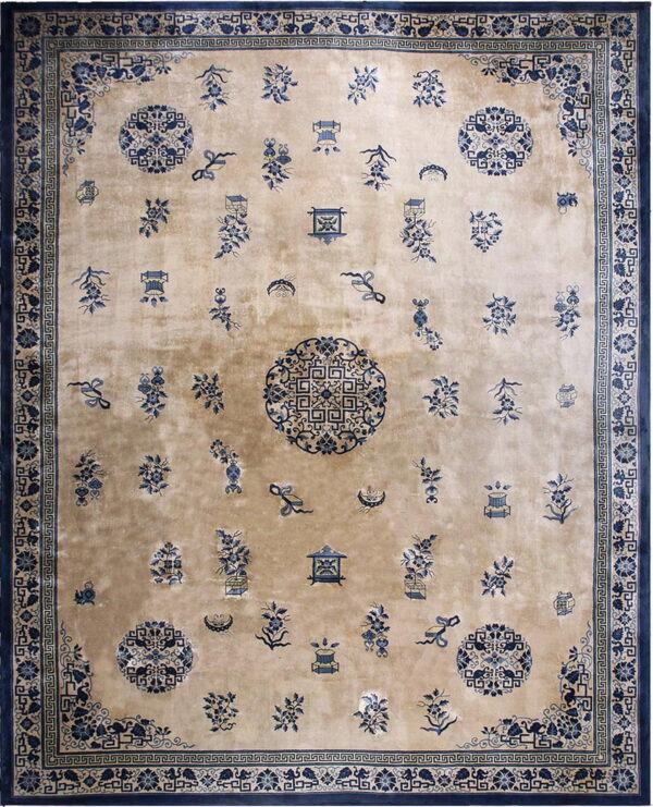 Tan field rug with scattered blue floral motifs, vases, and medallions, framed by wide geometric borders.
