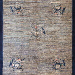 Navy-bordered rug featuring a striped blue and tan field with five scattered botanical medallion designs.