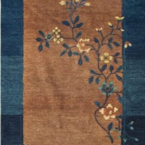 A long rug runner with a tan field and a navy blue border, featuring blue and yellow floral motifs.