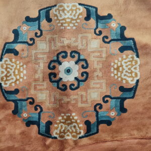 Close-up of a high-pile rug showing a central medallion in blue, cream, tan, and rust.