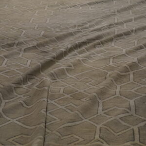 Draped beige rug features a repeating subtle geometric trellis pattern of light intersecting lines.