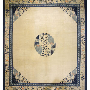 Cream area rug featuring navy and light blue bird and vine motifs in the center and corners.
