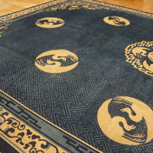 Navy and gold rug featuring large bird roundels and geometric lattice borders on light wood flooring.