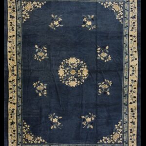 Deep blue rug with cream and light blue floral designs in the field and wide contrasting border.