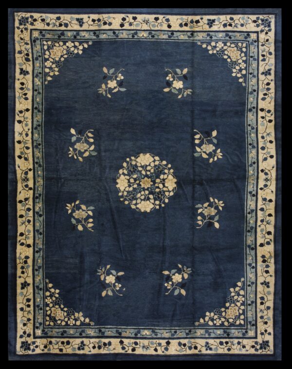 Deep blue rug with cream and light blue floral designs in the field and wide contrasting border.