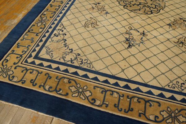 Beige rug with blue diamond trellis, framed by wide blue and mustard gold ornate borders on wood floor.