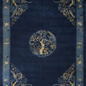 Deep navy rug with a gold and blue central tree medallion and figurative floral borders.