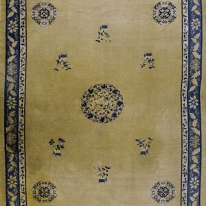 A pale olive rug with a central medallion and scattered motifs, featuring wide indigo blue floral borders.