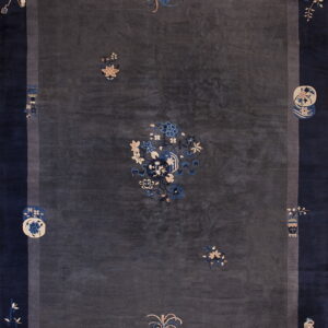 Dark gray rug with a wide navy blue border and scattered traditional motifs in cream and light blue.