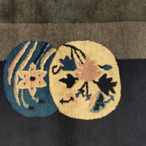 Plush rug detail showing dark green and navy fields with round yellow and teal flower pattern accents.