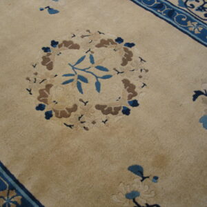 Beige plush rug with sculpted floral patterns in shades of blue, brown, and tan.