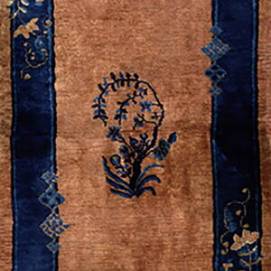Brown runner rug features wide navy blue borders and alternating stylized blue floral motifs in the center.