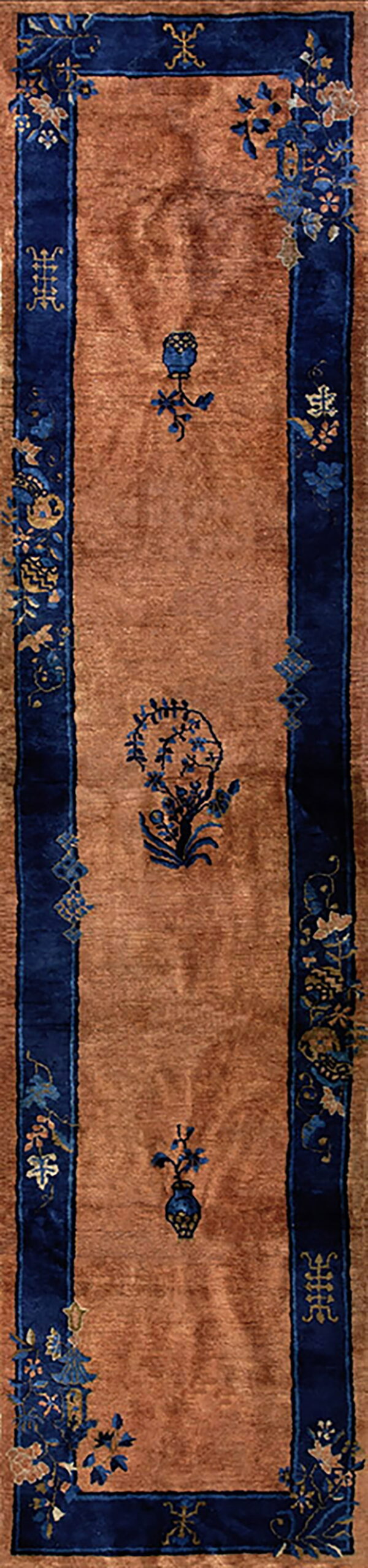 Brown runner rug features wide navy blue borders and alternating stylized blue floral motifs in the center.