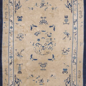 Rectangular pale gold rug with detailed dark blue stylized symbols and broad indigo border.