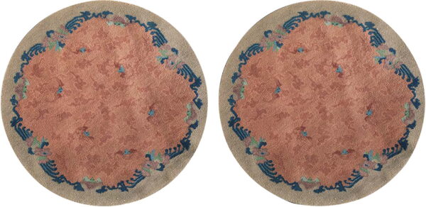 Two identical circular rugs with pink centers and blue scalloped decorative borders.