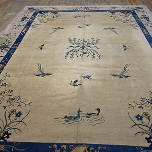 Beige rug featuring a blue bird and floral pattern with a thick blue outer border on wood flooring.