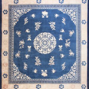 Blue and cream rug featuring a central floral medallion, scattered motifs, and geometric borders.