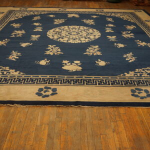 Low-pile rug in blue and cream with a detailed floral and geometric meander pattern on wood planks.