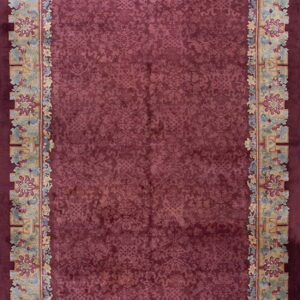 Burgundy rug with an ornate tone-on-tone field and broad, colorful floral and geometric borders.