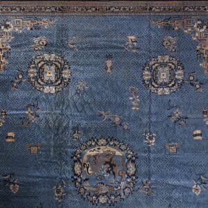 Blue low-pile rug featuring a complex lattice pattern, tan medallions, and thick geometric borders.