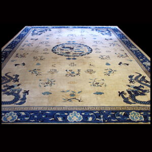 Cream and blue low-pile rug featuring dragons, a central medallion, and decorative borders on a black background.