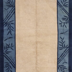 Beige rug with a light lattice pattern and a wide border of blue bamboo leaves and dark blue accents.
