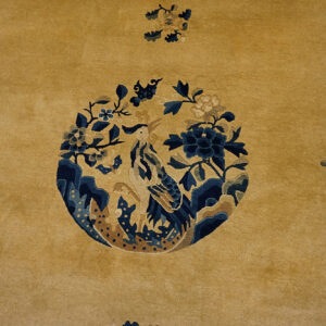 Yellow rug with floral and bird design.