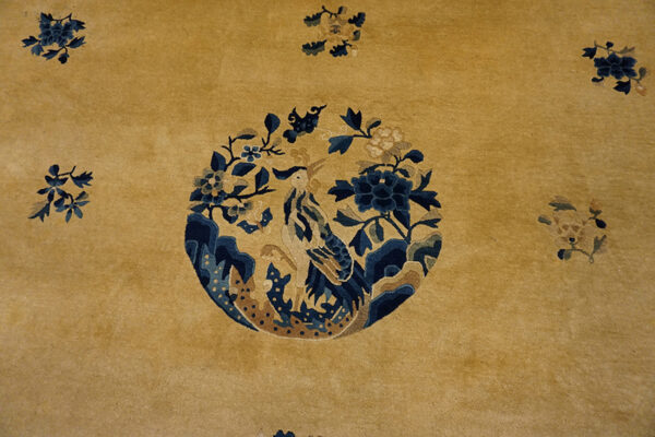 Yellow rug with floral and bird design.