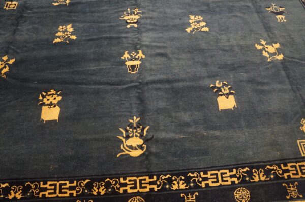 Dark blue rug featuring scattered gold floral designs and a navy border with geometric patterns.