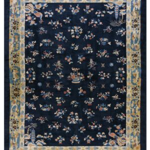 Navy blue rug with multicolored scattered motifs and a wide, detailed tan and blue border.