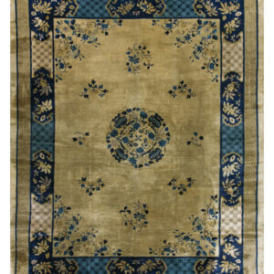 Beige rug with navy and teal borders, featuring a central medallion and scattered blue floral sprays.