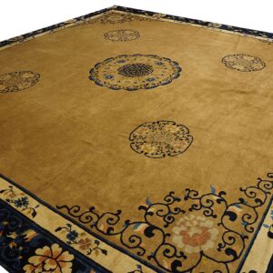 Mustard-toned rug featuring a navy blue patterned border and decorative floral medallions.