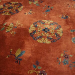 Rust-colored rug with yellow and blue circular floral medallions and scattered vine motifs.