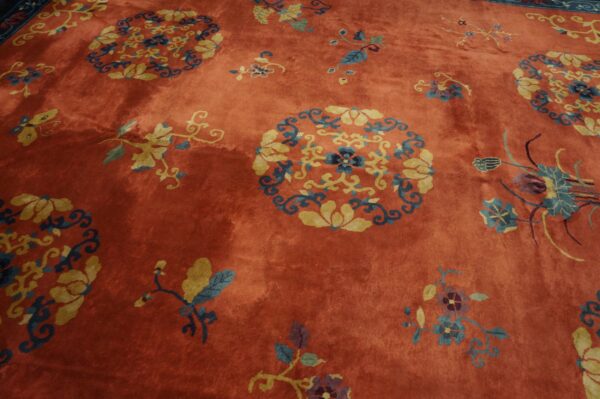 Rust-colored rug with yellow and blue circular floral medallions and scattered vine motifs.