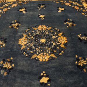Ornate navy rug with gold floral sprays and a central medallion on visible wood flooring.