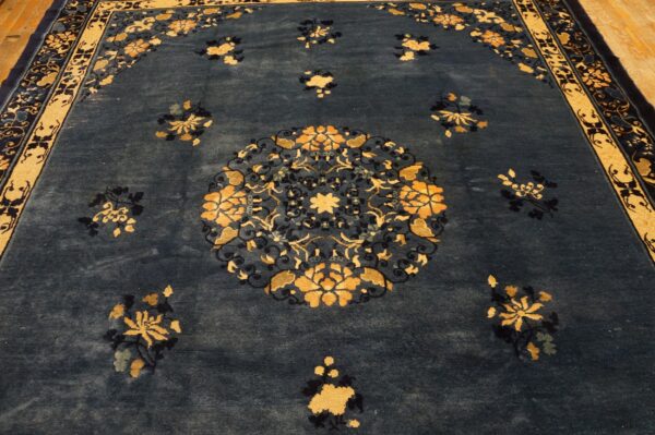 Ornate navy rug with gold floral sprays and a central medallion on visible wood flooring.