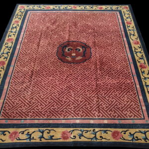 Red geometric rug with a dark central medallion and wide gold borders featuring blue scrolling floral motifs.