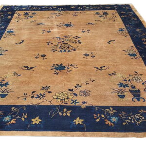 Tan traditional rug with a wide navy border featuring scattered floral and vase patterns in blue and gold.