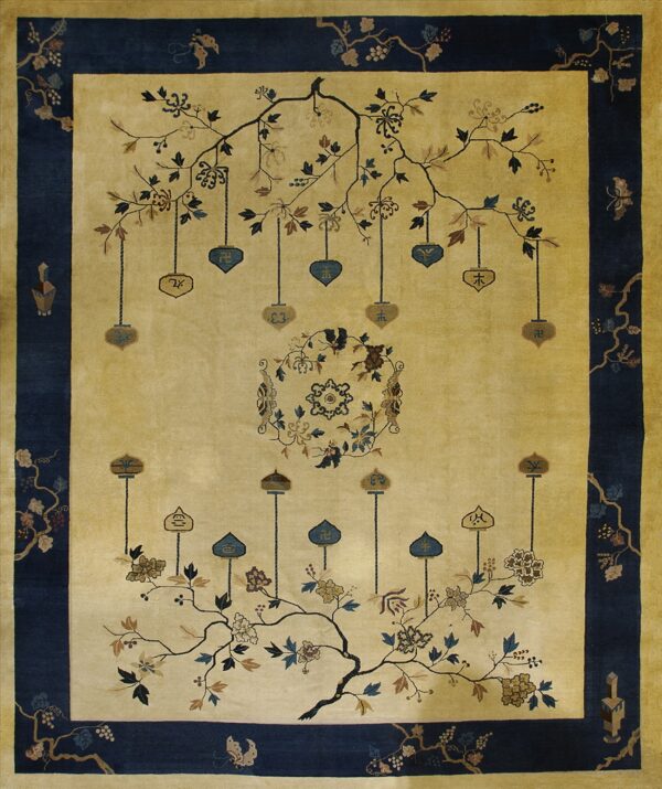 Cream and dark blue pictorial rug featuring stylized flowering branches and hanging symbolic pendants.