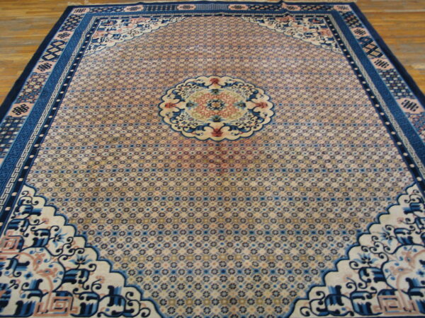 Ornate blue and pale pink rug featuring a micro-patterned field and intricate medallion rests on wooden planks.
