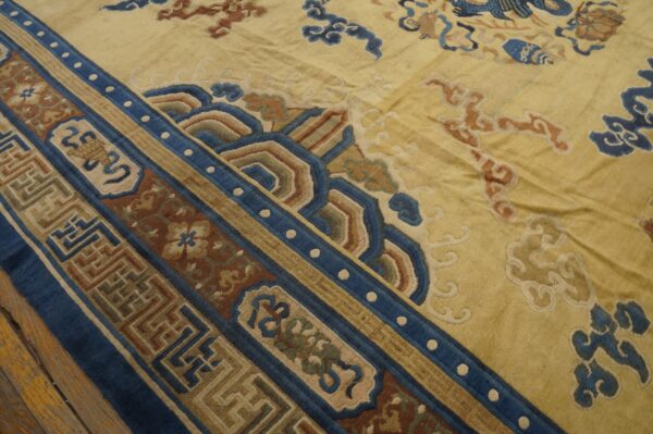 Yellow field rug with complex blue, rust, and tan geometric borders and stylized cloud motifs.
