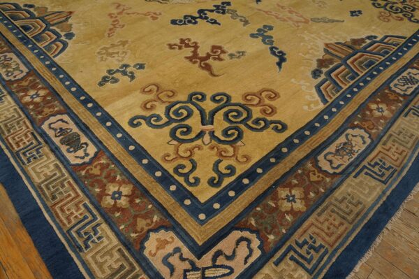 Golden yellow rug corner featuring complex blue and rust borders and scattered stylized cloud patterns.