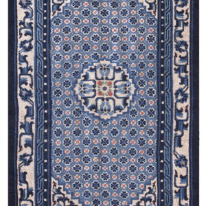 Blue and cream rug with a geometric floral pattern and ornate multi-layered borders.