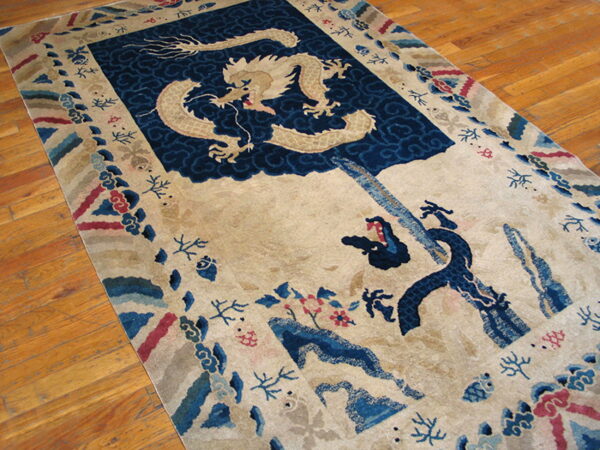 Cream rug with a beige dragon on indigo clouds and multicolored borders, displayed on wood floors.