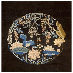 A black rug featuring a large circular medallion with blue, pink, and beige floral elements.