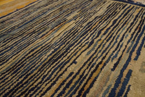 Distressed rug detail featuring diagonal wavy dark blue and tan textured stripes.