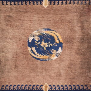 Brown rug featuring a navy blue medallion with gold flowers, surrounded by detailed floral borders.