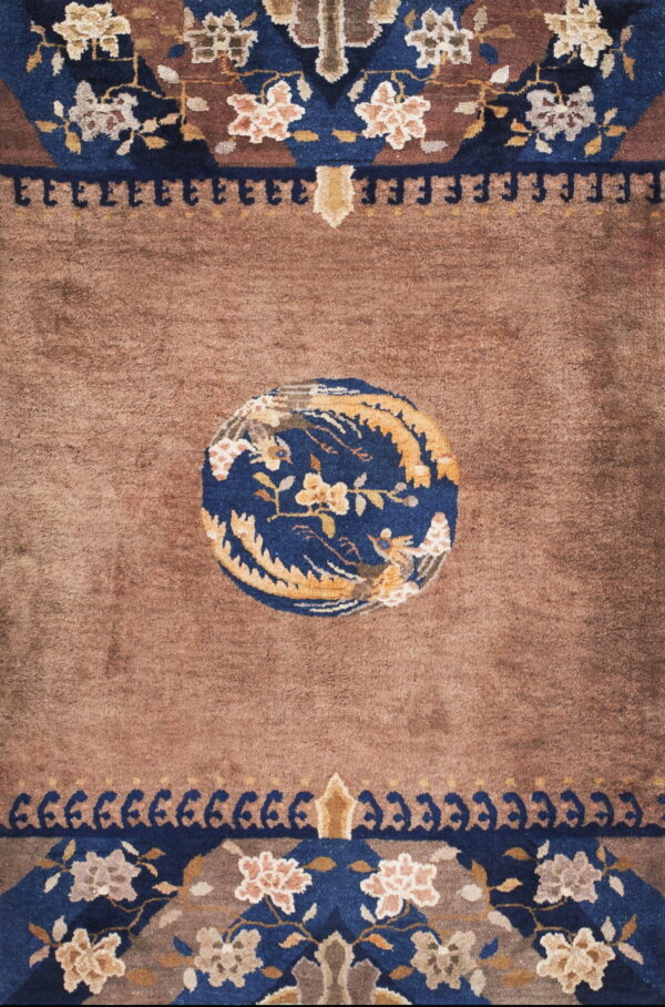 Brown rug featuring a navy blue medallion with gold flowers, surrounded by detailed floral borders.