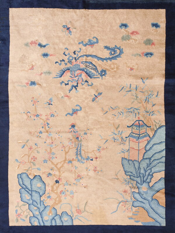 Beige rug with dark blue border featuring a light blue bird, pagoda, and flowering tree pattern.
